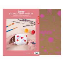 Load image into Gallery viewer, Packaging shows pink sleeve over a cardboard box. Photo on the sleeve shows light-skinned hands painting a mug using the brushes and paint.
