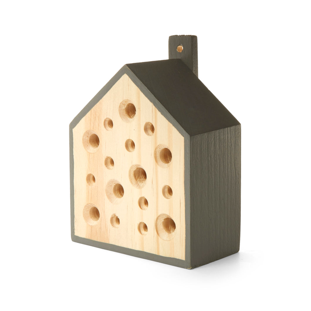 Little Bee House diagonally facing camera. Sides of house and hook are stained or painted dark grey. A bronze coloured nail, or hook is stuck into the small post attached to the back. The front of the box is natural wood with 16 holes of various sizes.