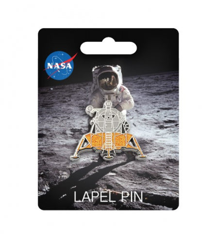 Pin badge attached to card with image of astronaut on the moon. The badge is silver and gold and shaped like space shuttle. The card has the NASA logo in the top left.