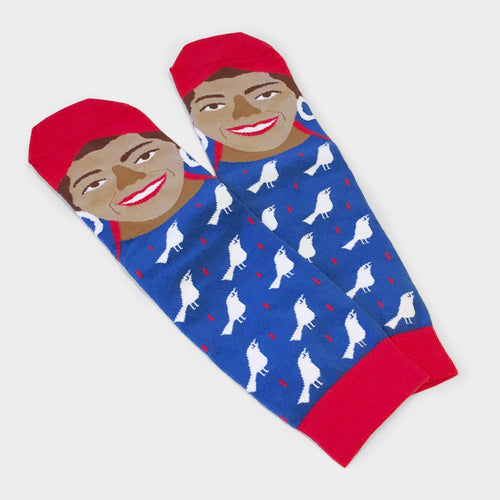 Blue socks with white birds and red trim. On the feet are a face with white hoop earrings, red head wrap, and red lips.