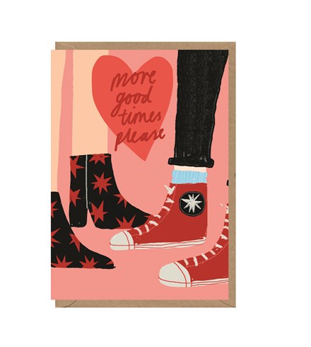 Pink card with brown kraft envelope tucked inside. Illustration shows two legs and feet. One pair of shoes is black boots with red stars, the other pair of shoes are red converse. In a red heart, 'more good times please' is written in a darker red cursive font. Both legs are light-skinned.