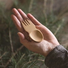 Load image into Gallery viewer, A spork is cupped in an light-skinned adult&#39;s hand, to show the scale. There is a tree in the background.
