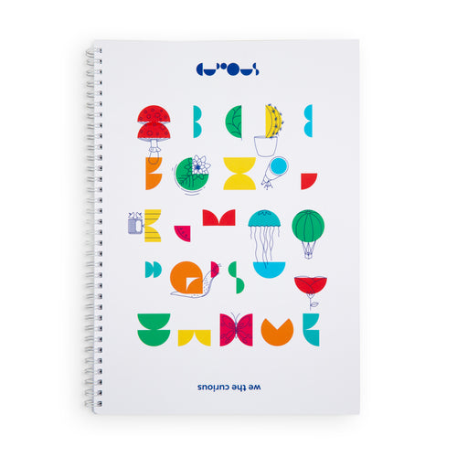 White notebook has white spiral. Colourful patterns on the front show the We The Curious alphabet with drawings on top. At the top of the notebook is the We The Curious logo, and underneath is the name 
