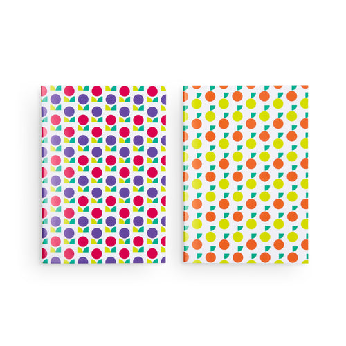 Two notebooks side by side. On the left is a notebook with purple and red flowers. On the right, the notebook design shows limes and mandarin oranges. 