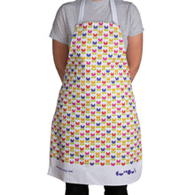 Load image into Gallery viewer, White woman wearing the apron over a grey shirt and black trousers with her hands behind her back. 
