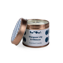 Load image into Gallery viewer, Candle in rose gold tin has white label with &quot;stargazer lily &amp; hibiscus scented candle&quot; printed. Lid is tilted against the tin. 
