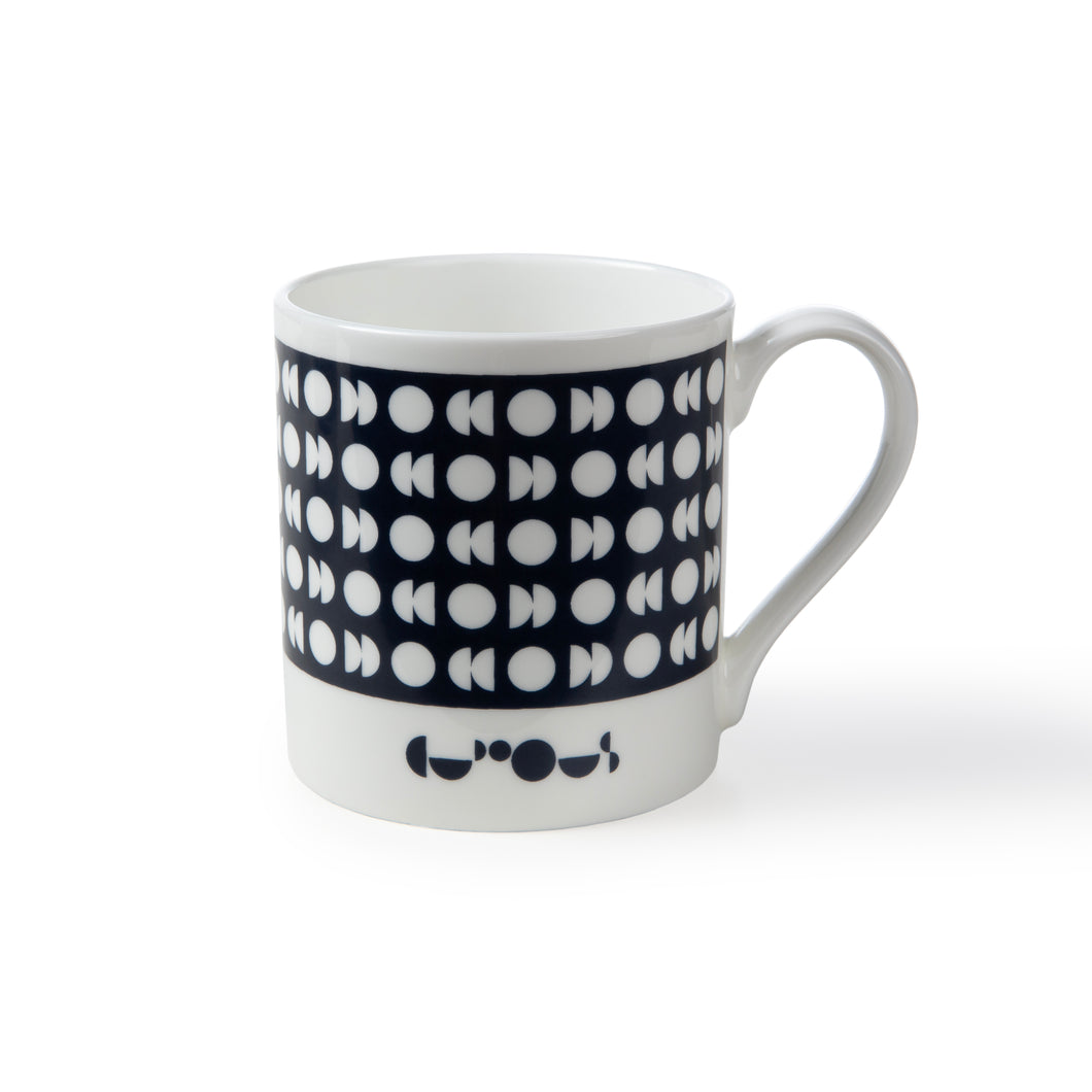 White mug with a dark blue band and white moon phase patterns. We The Curious logo sits below dark blue band. 
