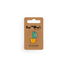 Load image into Gallery viewer, Green cactus in orange pot pin badge sits on a brown cardboard backer with We The Curious logo and the phrase &quot;pin badge&quot; below. 
