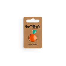 Load image into Gallery viewer, Mandarin orange with green leaf pin badge sits on a brown cardboard backer with We The Curious logo and the phrase &quot;pin badge&quot; below.

